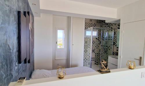 une chambre avec un lit et un miroir dans l'établissement Cyllène Port Nature 5, au Cap d'Agde