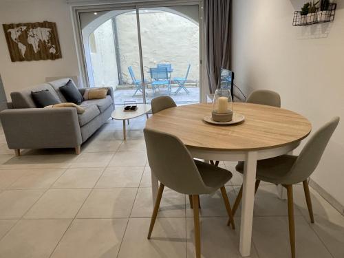 - une table à manger et des chaises dans le salon dans l'établissement Appartement climatisé avec cour en centre ville, à Carpentras