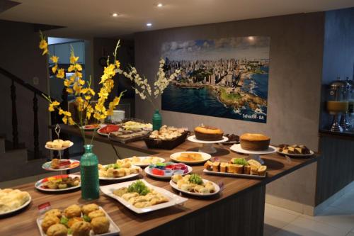 a buffet with many plates of food on a table at Onix Hotel Praia de Piata in Salvador