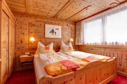 a bedroom with a bed in a wooden room at Alpenruh in Pettneu am Arlberg