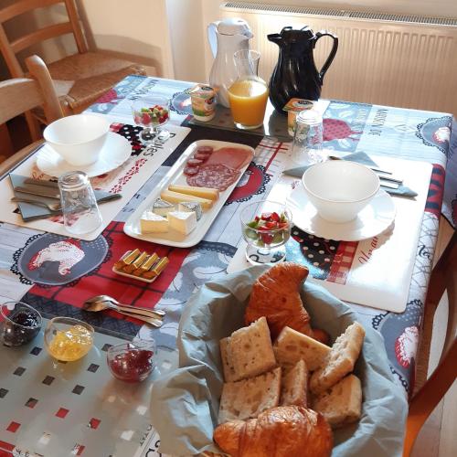 a table with a plate of bread and orange juice at La maison in Tarnac