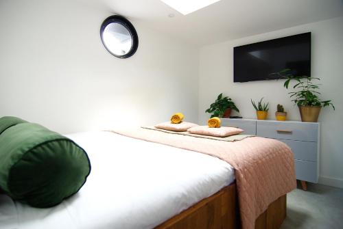a bedroom with a bed with a tv on the wall at Magnificent houseboat with a stunning view! in Amsterdam