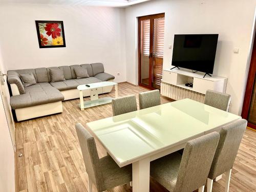 ein Wohnzimmer mit einem Tisch und einem Sofa in der Unterkunft Apartments Family in Tivat