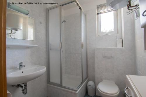 a bathroom with a shower and a sink and a toilet at Dünenhaus Fewos - Zum Strand 50m in Ueckeritz