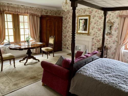 a bedroom with a bed and a table and a chair at Highland Bear Lodge & Luxury Bear Huts in Drumnadrochit