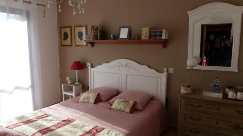 ein Schlafzimmer mit einem Bett mit rosa Kissen darauf in der Unterkunft LE CABANON in Crillon-le-Brave