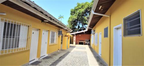 une ruelle étroite entre deux bâtiments jaunes dans l'établissement Encantos do Lázaro, à Ubatuba