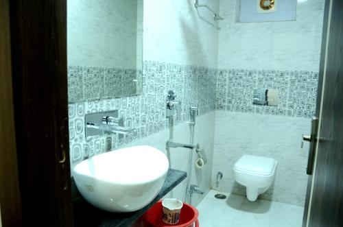 a bathroom with a white sink and a toilet at Hotel hari palace in Jhānsi