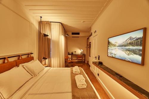 a hotel room with a bed and a television on the wall at Regno Di Morea in Nafplio