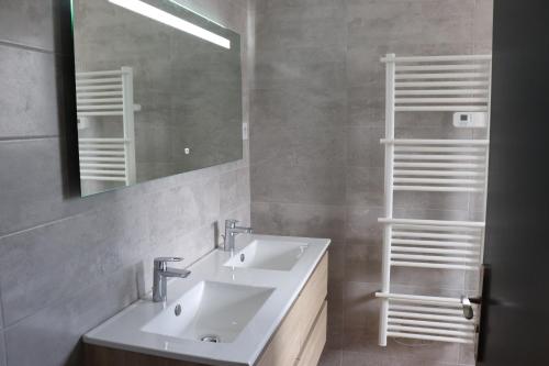 une salle de bain avec deux lavabos et un miroir dans l'établissement Gîte les Pervenches avec Sauna, à Gérardmer