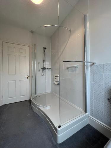 a bathroom with a shower with a glass door at Spacious bungalow with large private garden in Hilperton