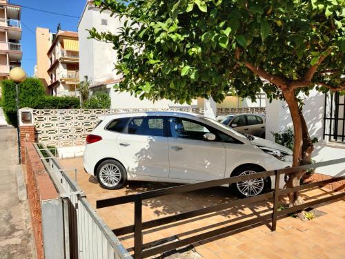 ein weißes Auto, das neben einem Baum parkt in der Unterkunft Casa CHALET INDEPENDIENTE en CALLE PRIVADA in Los Mártires