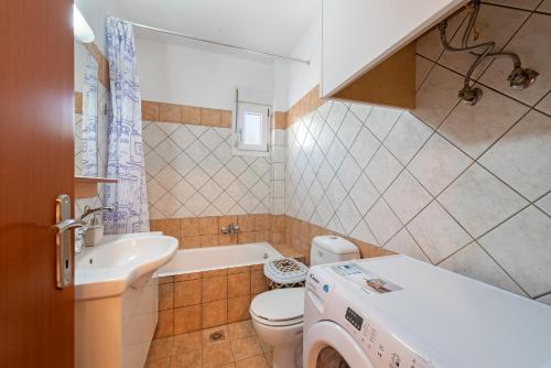 a bathroom with a toilet and a sink and a tub at Lagadi Apartment 8 in Lassi
