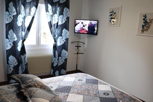 - une chambre avec une télévision murale dans l'établissement Gîte les Pervenches avec Sauna, à Gérardmer