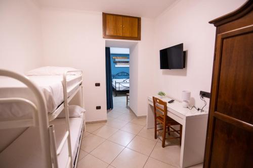 a dorm room with a bed and a desk with a computer at Pompei Luxury Rooms in Pompei