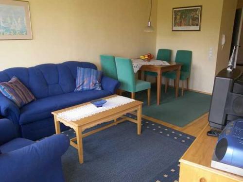 sala de estar con sofá azul y mesa en Seepark Bansin App 101, en Bansin