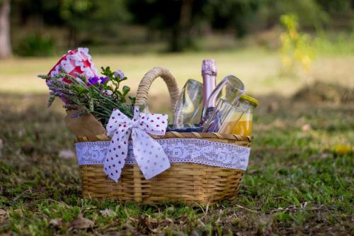 a picnic basket with utensils and flowers on the grass at Hotel Resort e Golfe Clube dos 500 in Guaratinguetá