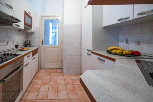 a kitchen with a plate of fruit on the counter at Bright and Modern 1BDR Apartment in the Center in Sarajevo