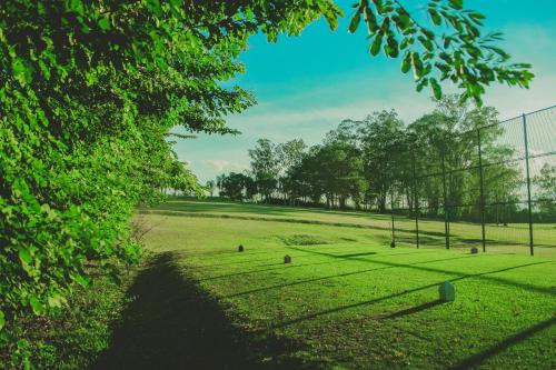 a field of grass with a fence and trees at Hotel Resort e Golfe Clube dos 500 in Guaratinguetá