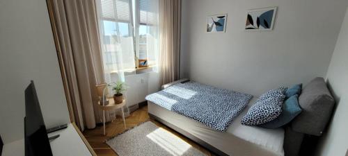 Habitación pequeña con cama y ventana en Apartament Abrahama, en Władysławowo