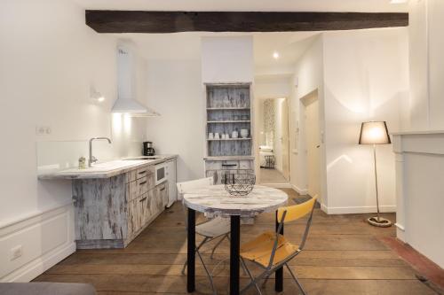 a kitchen with a table and chairs and a sink at Appartement R1 T2 Rodez Centre Historique in Rodez
