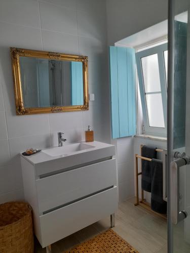 a bathroom with a white sink and a mirror at Carlo's Beach Guest House in Praia de Odeceixe