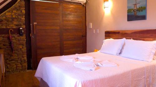 a bedroom with a bed with two towels on it at Pousada Pedra Grande in Serra de São Bento