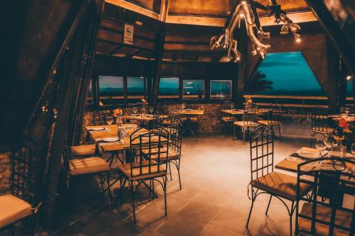 a restaurant with tables and chairs in a room at Pousada Pedra Grande in Serra de São Bento
