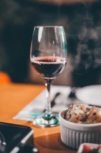 a glass of wine sitting next to a bowl of food at Pousada Pedra Grande in Serra de São Bento