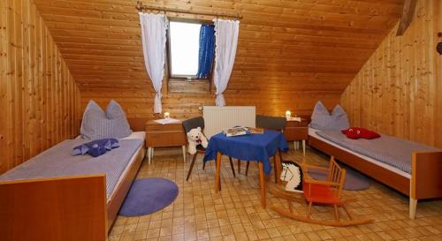 una habitación con 2 camas y una mesa en una cabaña en Ferienhof Biber en Witzmannsberg