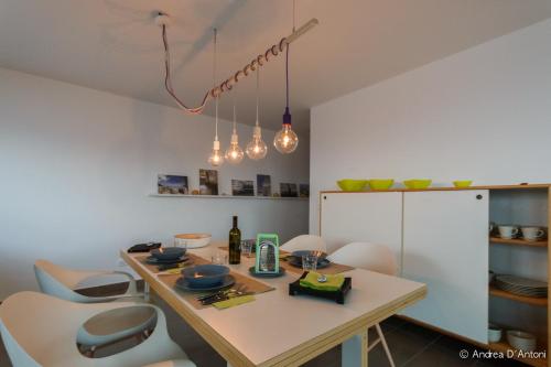 a kitchen with a table with chairs and lights at Seafront Holiday House on the Mindelo Bay in Mindelo
