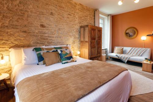 une chambre avec un grand lit et un mur de briques dans l'établissement Ty Mad, à Douarnenez