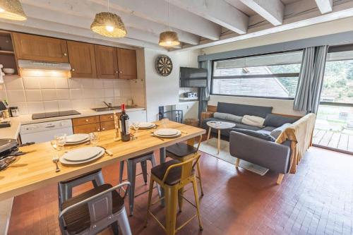 uma cozinha e sala de estar com uma mesa e um sofá em La Cabane du Cerf à Payolle em Campan