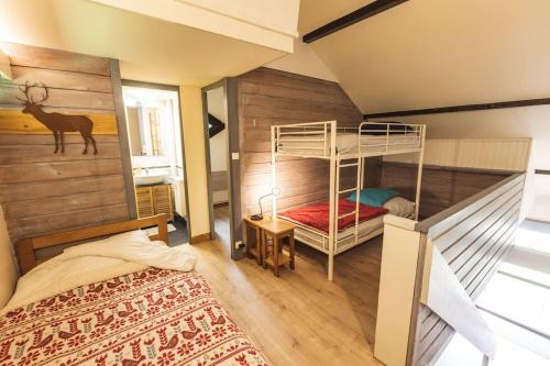 La Cabane du Cerf à Payolle في كامبان: غرفة نوم بسريرين بطابقين في غرفة