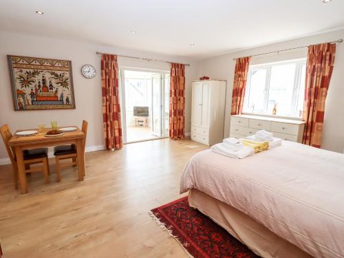 a bedroom with a bed and a table and a desk at Deer View in Witney