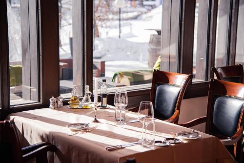 a table in a restaurant with chairs and a window at Hotel San Gian in St. Moritz