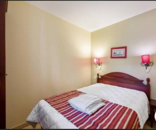 - une chambre avec un lit et deux lampes murales dans l'établissement Biscarrosse Lac-Domaine de Gascogne- avec piscine, à Biscarrosse