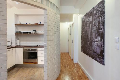 - une cuisine avec des murs blancs et un mur en briques dans l'établissement Apartment Saint Germain des Prés by Studio prestige, à Paris