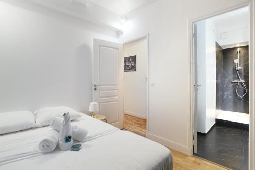 - une chambre blanche avec un lit et une salle de bains dans l'établissement Apartment Saint Germain des Prés by Studio prestige, à Paris