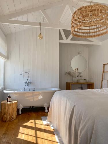 um quarto com uma banheira e uma cama em Ragnar Glamp Milzkalne Forest em Rauda