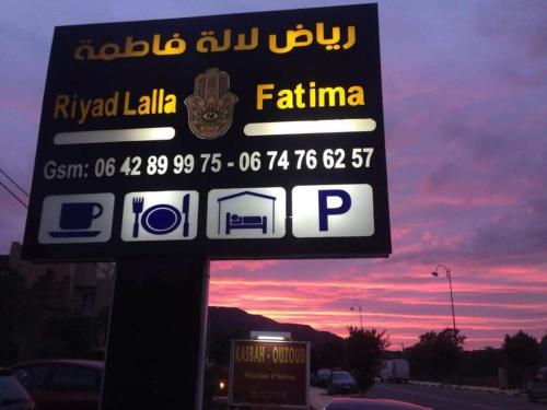 a sign for a petrol station with a sunset in the background at riad lala fatima in Ouzoud