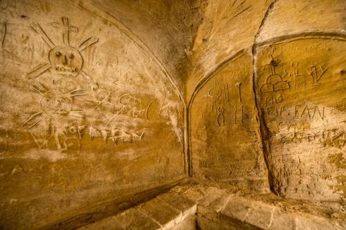 a cave with graffiti on a wall with a skull at Abbazia Collemedio Resort & Spa in Collazzone