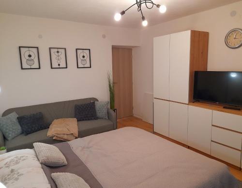 a living room with a couch and a flat screen tv at Apartman Sunny Lika in Gospić