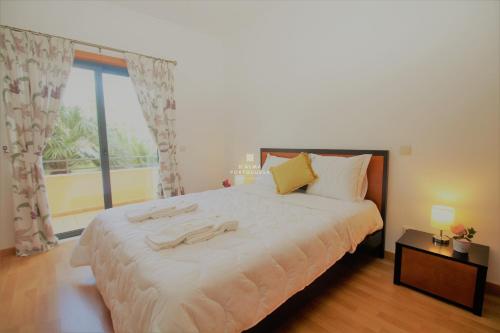 a bedroom with a large bed and a large window at Apartment Garcas Lounge - By Dalma Portuguesa in Albufeira