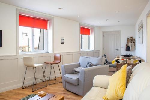 a living room with a couch and two chairs at The Anchor Apartments in Ardglass