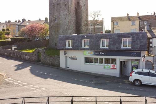 a white car parked in front of a building at The Anchor Apartments in Ardglass