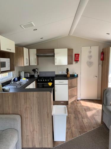 a kitchen with wooden cabinets and a counter top at Newquay Bay Resort 63 in Newquay Bay Resort