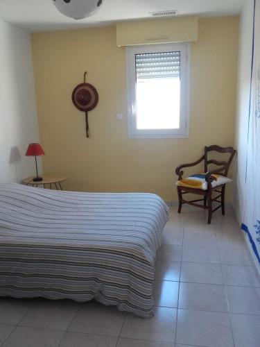 une chambre avec un lit, une fenêtre et une chaise dans l'établissement LE CALME AU COEUR DE LA VILLE, à Nîmes