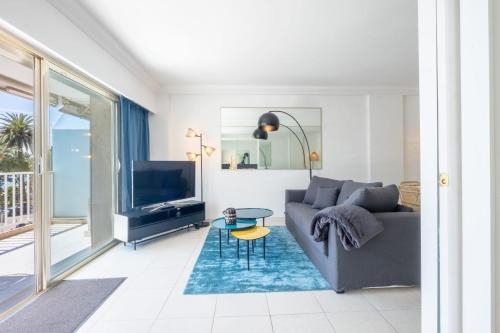 a living room with a couch and a tv at SERRENDY Sea view terrace upscale property in Cannes