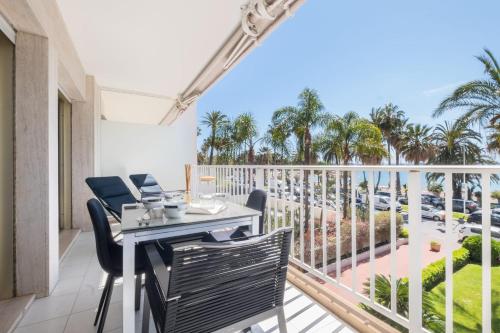 balcón con mesa, sillas y vistas al océano en SERRENDY Sea view terrace upscale property, en Cannes